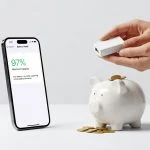 iPhone showing high battery health percentage with hands holding USB charge limiter over piggy bank