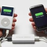 Hands holding vintage iPod and Android phone connected to modern USB charge limiter, nostalgic tech preservation