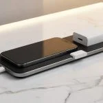 Modern wireless charging pad with iPhone and small USB charge limiter device, clean product photography