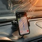 Smartphone mounted on a hot car dashboard running navigation with visible heat shimmer