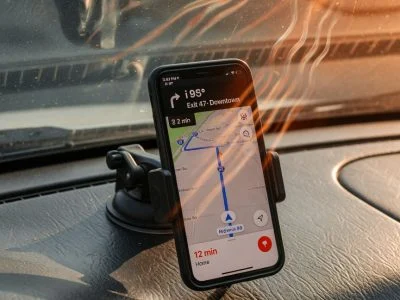 Smartphone mounted on a hot car dashboard running navigation with visible heat shimmer