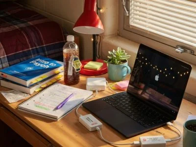 Student laptop charging setup in dorm room with USB charge limiter between power adapter and laptop computer