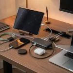 A multi-port USB-C charging station with several devices plugged in on a modern desk